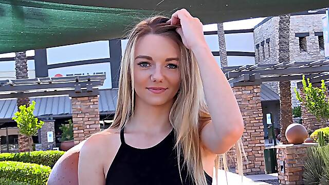 Affectionate solo model blonde with long hair in thong stripteasing seductively outdoor